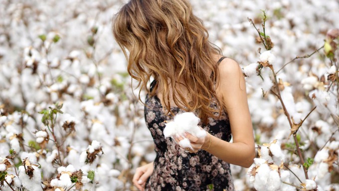 Woman in a cotton field wearing a cotton dress with medium fabric frequency