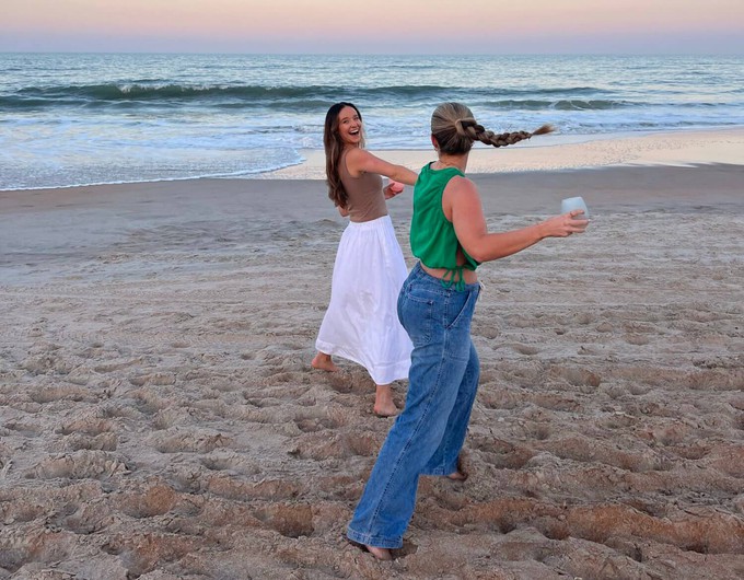 Friends laughing on the beach and wearing different clothes